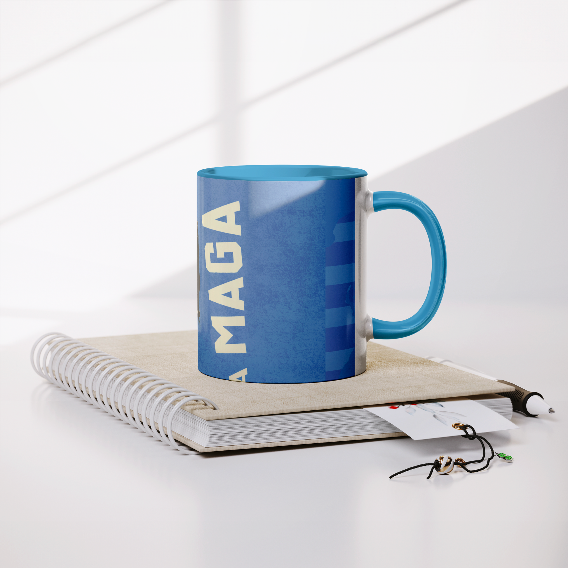 MAGA_KING_11oz_Blue_Accent_Mug_Lifestyle_Notebook_Mockup.png